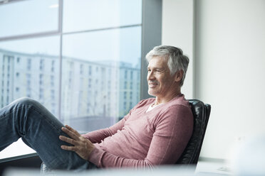 Man relaxing in a leather chair at home - RBF002622