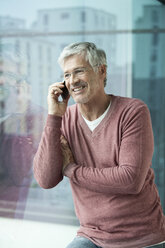 Portrait of smiling man telephoning with smartphone - RBF002635
