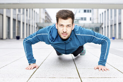 Germany, Magdeburg, portrait of young man doing pushups - SEGF000312