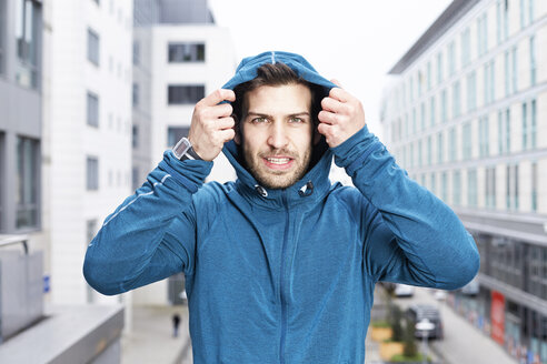 Germany, Magdeburg, portrait of young man wearing blue hooded jacket - SEGF000327