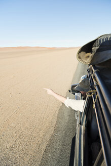 Namibia, Namib-Wüste, Namib Naukluft Park, Sossusvlei, Mann im Auto zeigt mit dem Finger - CLPF000095