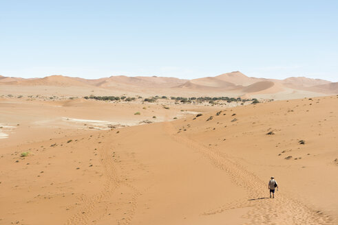 Namibia, Namib-Wüste, Namib Naukluft Park, Sossusvlei, Mann geht durch die Wüste - CLPF000101