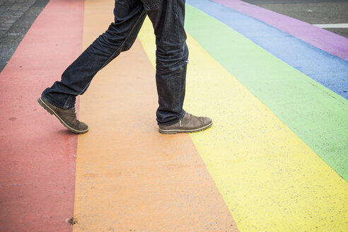 Niederlande, Maastricht, Mann geht auf Regenbogenflagge, die auf die Straße gemalt ist - RIBF000028