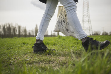 Deutschland, Zons, Frau geht auf einer Wiese - RIBF000012