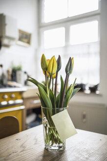 Adhesive note gluing at glass with tulips on a kitchen table - RIBF000021