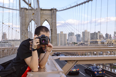 USA, New York, Reisender fotografiert Manhattan von der Brooklyn Bridge am Abend - GEMF000204