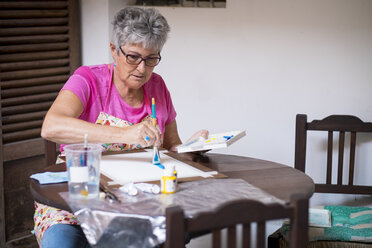 Ältere Frau malt ein Bild - ABAF001649