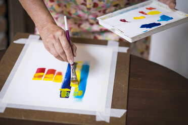 Senior woman painting an abstract picture, close-up - ABAF001658