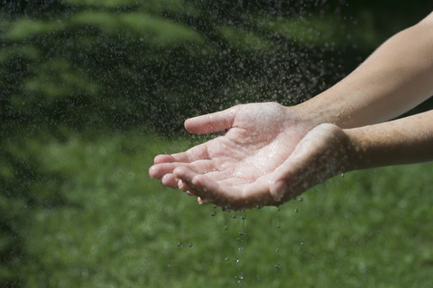 Wassertropfen auf den Händen einer Frau, lizenzfreies Stockfoto