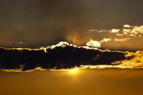 Die Sonne versteckt sich hinter einer Wolke, lizenzfreies Stockfoto