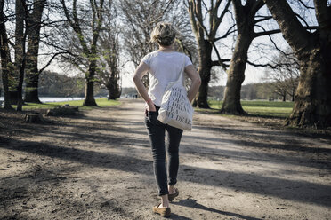 Deutschland, Köln, alleinstehende Frau beim Spaziergang im Stadtpark - RIBF000030