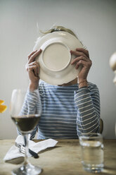 Frau leckt einen Teller zu Hause ab - RIBF000031