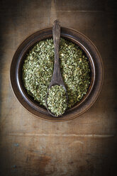 Bowl of dried peppermint on wood - EVGF001729