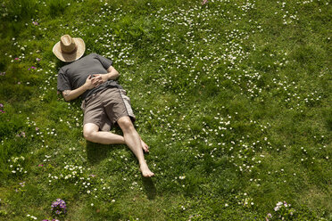 Man lying in grass relaxing - MIDF000320