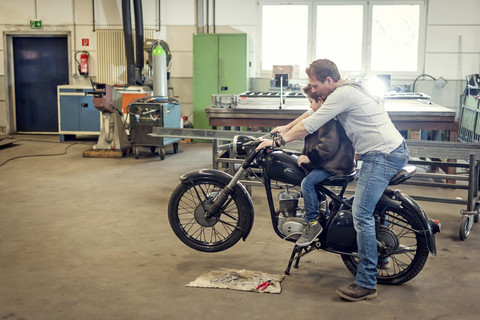 Vater und Sohn warten altes Moped, lizenzfreies Stockfoto