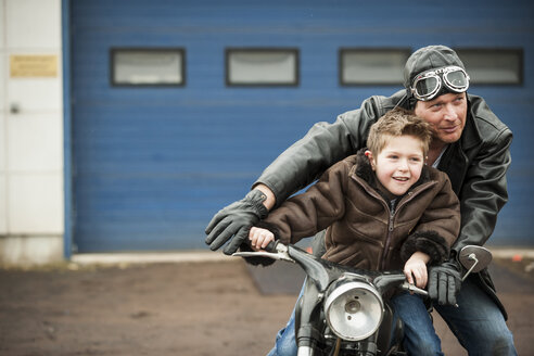 Father and son driving with vintage moped - PAF001284