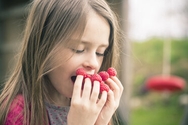 Girl eating raspberries from her fingers - SARF001714