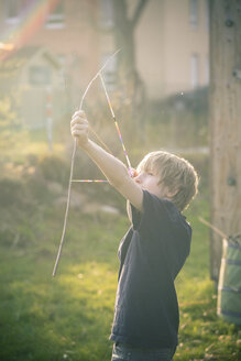Junge mit selbstgebauter Schleife aus Zweigen und Webstühlen - SARF001724
