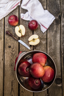 Rote Äpfel, Schuppen und Messer auf dunklem Holz - SARF001738