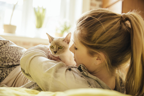 Woman with Burmese cat at home stock photo