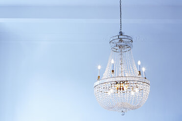Lighted old ceiling lamp in front of light blue wall - DISF002021