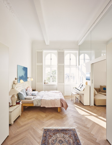 Schlafzimmer in einem renovierten Altbau mit Esstisch im Vordergrund, lizenzfreies Stockfoto