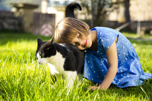 Kleines Mädchen mit Katze auf einer Wiese - LVF003198