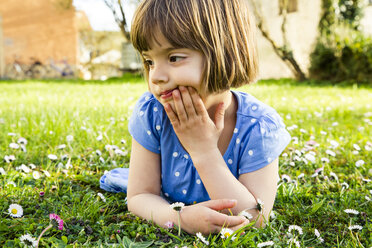 Pensive little girl lying on a meadow - LVF003195