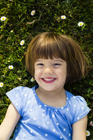 Portrait of happy little girl lying on a meadow stock photo