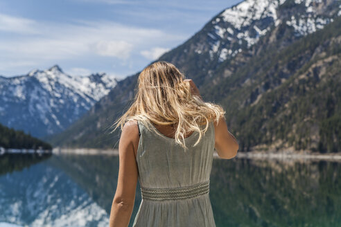 Austria, Tyrol, Lake Plansee, woman at lakeshore - TCF004621
