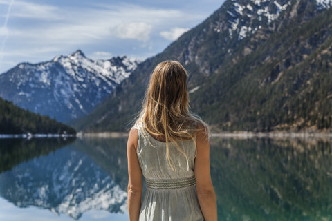 Österreich, Tirol, Plansee, Frau am Seeufer, lizenzfreies Stockfoto