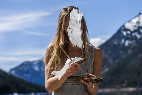 Österreich, Tirol, Plansee, Frau beim Aufbau eines Modellsegelbootes, lizenzfreies Stockfoto