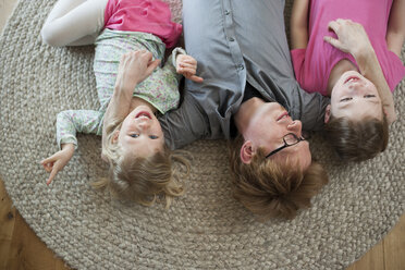 Father with two daughters lying on floor - PAF001332