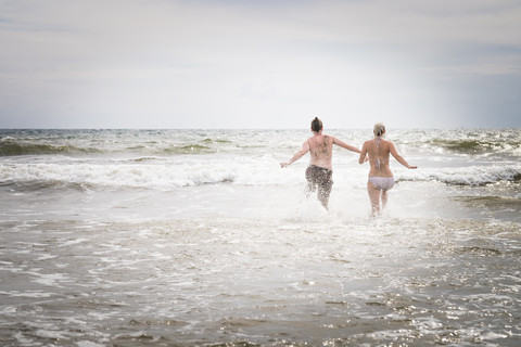Mexico, Riviera Nayarit, young couple running into the sea stock photo
