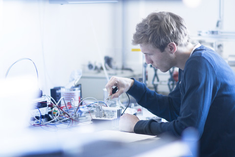 Techniker, der ein elektrisches Bauteil konstruiert, lizenzfreies Stockfoto