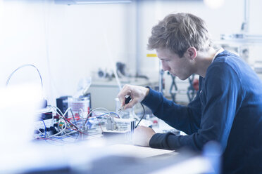 Technician constructing electric component part - SGF001524