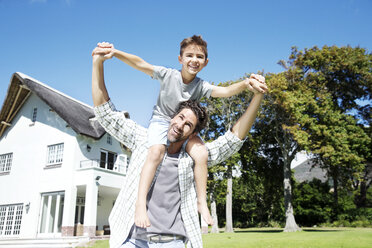 Father carrying son on shoulders, playing in garden - TOYF000029