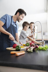 Father and children preparing food in kitchen - TOYF000044