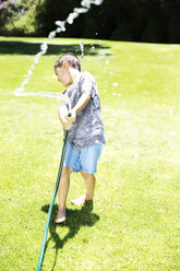 Boy splashing water with garden hose - TOYF000063