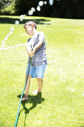 Boy splashing water with garden hose - TOYF000064
