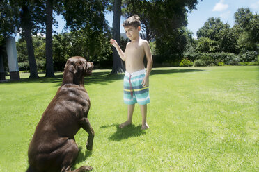 Junge spielt mit Hund im Garten - TOYF000068