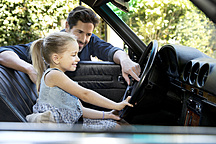 Vater zeigt der Tochter sein Auto, lizenzfreies Stockfoto
