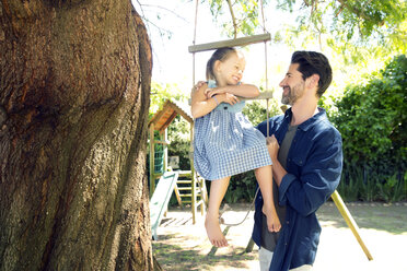 Father playing with daughter on swing - TOYF000089