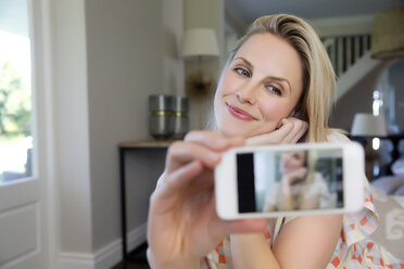 Blonde woman taking selfie with smartphone - TOYF000098