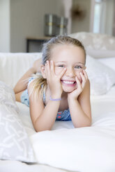 Little girl lying on sofa, laughing - TOYF000107