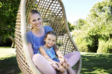 Mother and daughter relaxing in hanging chair - TOYF000125