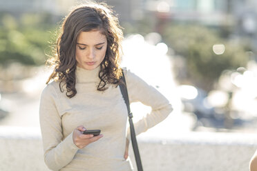 Young woman with cellphone in city - ZEF006321
