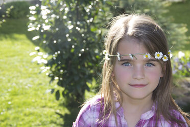 Portrait of little girl wearing floral wreath of daisys - YFF000409