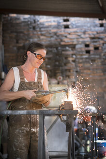 Schweißerin bei der Arbeit in einer Metallwerkstatt - ABAF001674