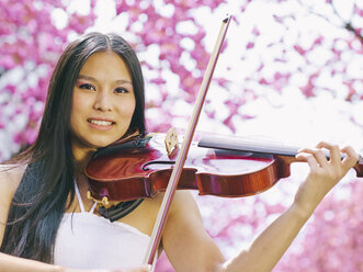 Portrait of female viola player in front of blossoming cherry tree - MADF000190